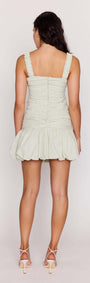 Back view of a model wearing the Green Gingham Bubble Mini Dress featuring bubble hem and textured seersucker fabric.