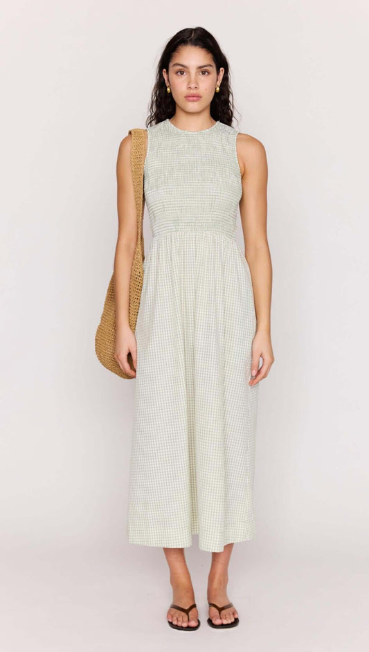 Model wearing the Green Gingham Smocked Midi Dress with a stylish bag, showcasing a fresh summer look.