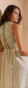 Model wearing the Green Gingham Smocked Midi Dress showcasing the tie-back detail and textured seersucker fabric.