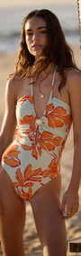 Green & Orange Floral Cut Out Swimsuit with Shell Embellishment worn by a model at the beach.