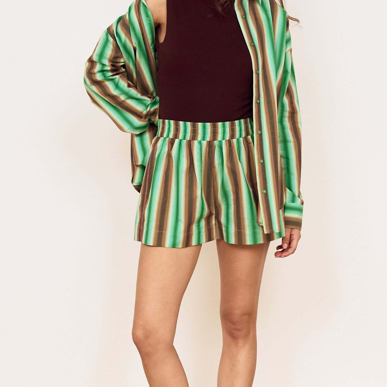 Model wearing Green Stripe Cotton Relaxed Short with a matching shirt and sandals, showcasing relaxed summer style.
