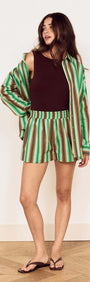 Model wearing Green Stripe Cotton Relaxed Short with a matching shirt and sandals, showcasing relaxed summer style.