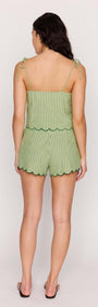 Back view of a woman wearing a Green Striped Linen Blend Scallop Cami Top with scalloped edges and adjustable tie straps.