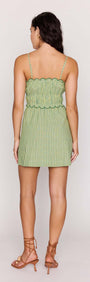 Back view of a model wearing a Green Striped Linen Blend Scallop Mini Dress with a shirred bodice and flared skirt.