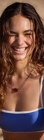 Model smiling in outdoor setting wearing HARLEY CONTRAST BIKINI TOP, showcasing its stylish design and vibrant colors.