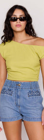 Model wearing High Waisted Cotton Blend Denim Short paired with a yellow cropped top and sunglasses.