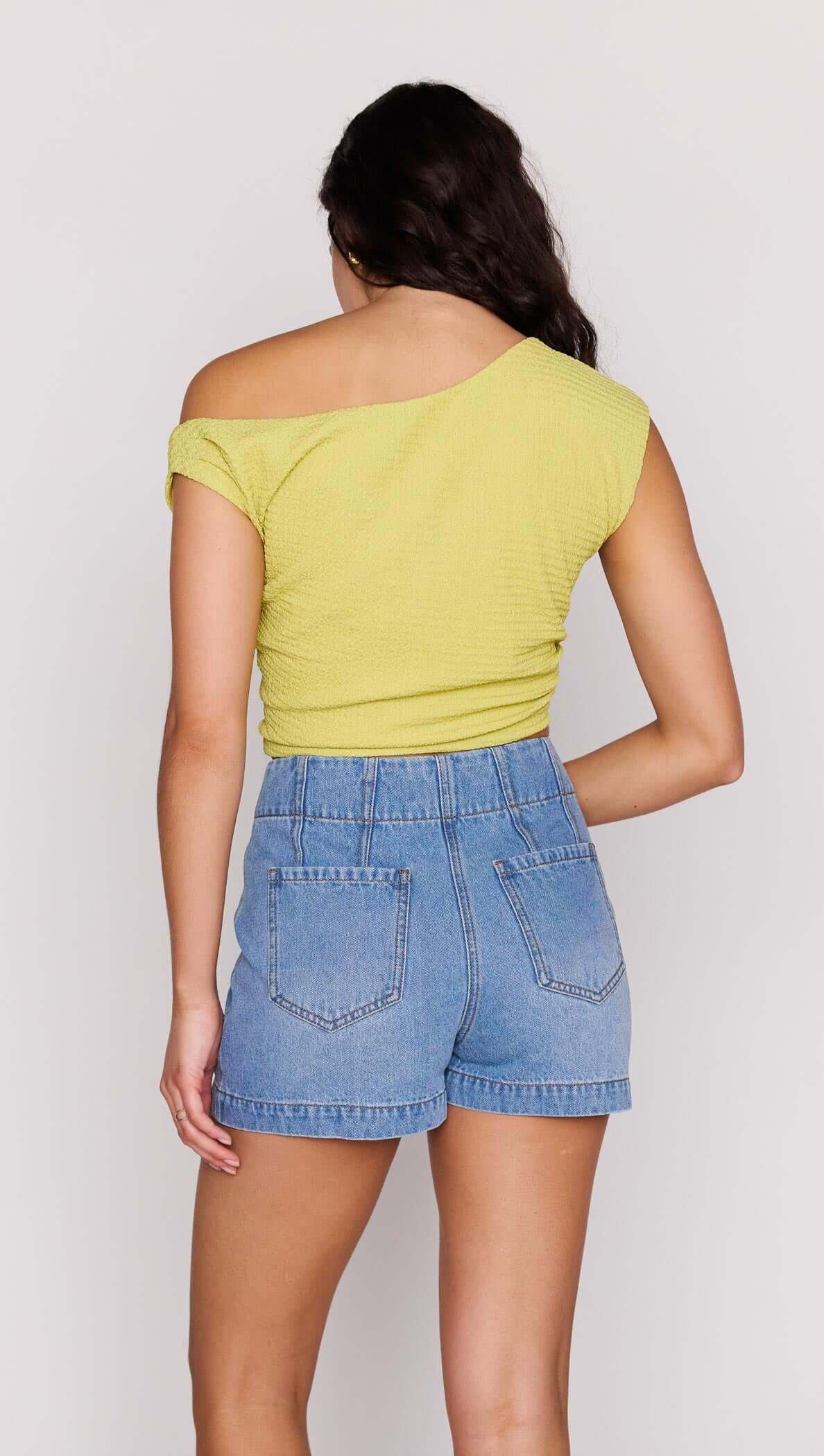 Model wearing a stylish High Waisted Cotton Blend Denim Short with a yellow top, showcasing a chic summer outfit.