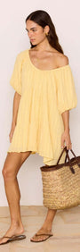 Relaxed Yellow Cotton Tiered Mini Dress worn with a woven bag, perfect for summer outings.
