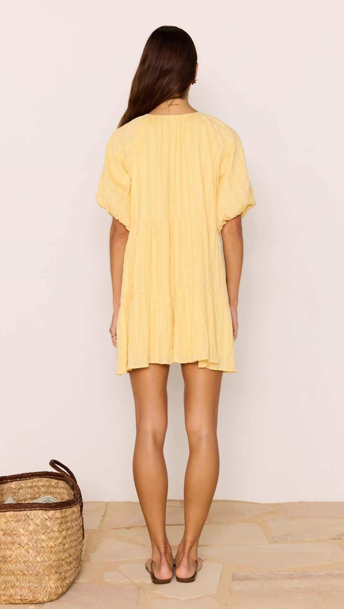Relaxed Yellow Cotton Tiered Mini Dress shown from the back, featuring a tiered design and voluminous sleeves.