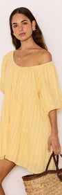 Relaxed Yellow Cotton Tiered Mini Dress worn by model with a straw bag, showcasing a soft crinkle texture and tiered design.