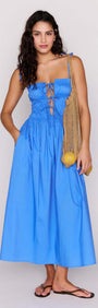 Model wearing a blue cotton tie detail midi dress with a shirred bodice and adjustable tie detailing.