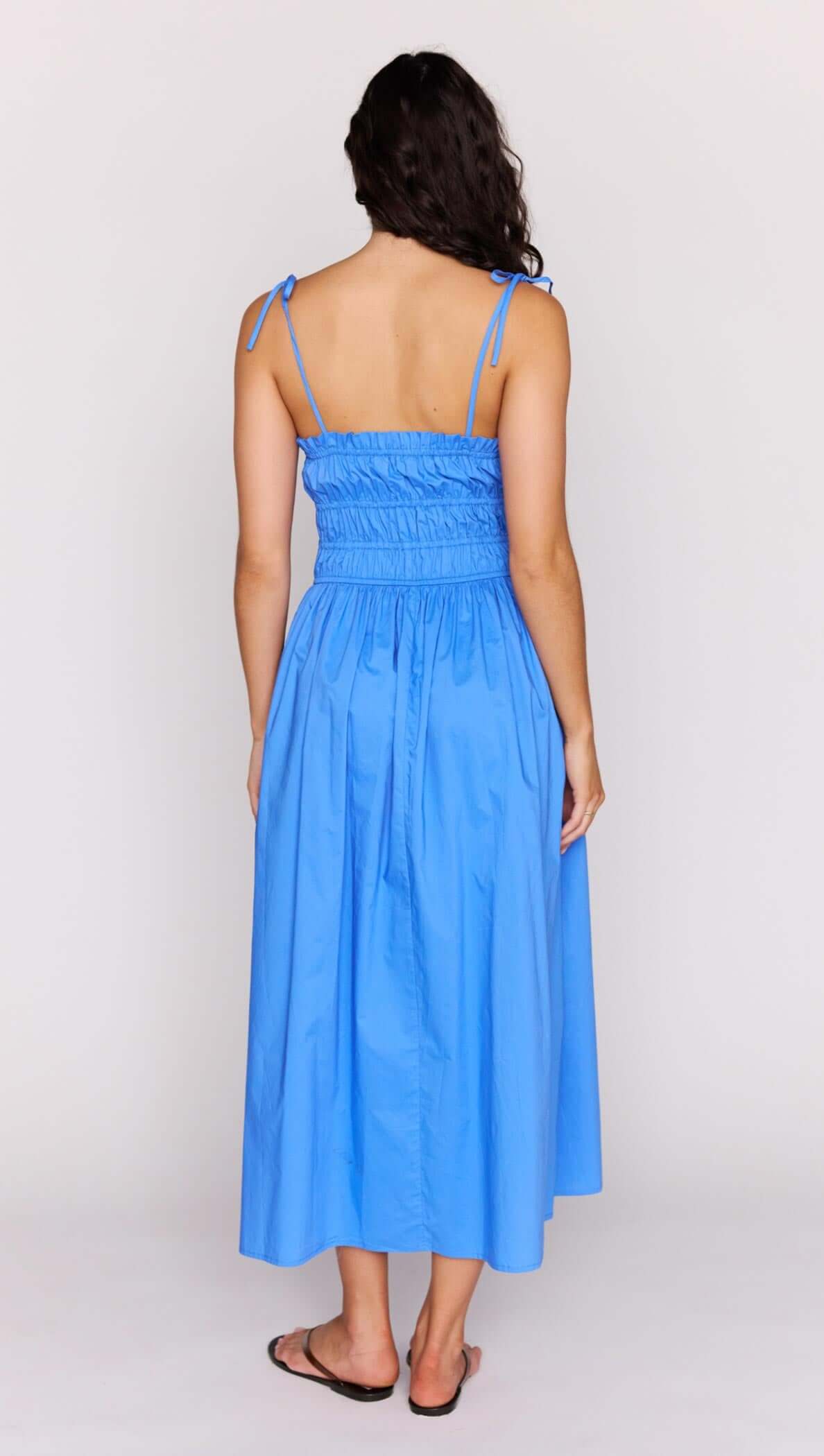 Back view of the Liana Blue Cotton Tie Detail Midi Dress showcasing the shirred bodice and playful design.