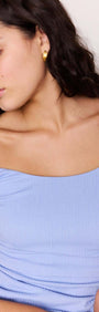 Model showcasing the Powder Blue Ruched Mini Dress featuring square neckline and wide shoulder straps.