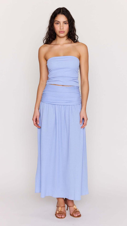 Model wearing a Powder Blue Strapless Crop Top with matching skirt, showcasing soft ruching and elegant summer styling.