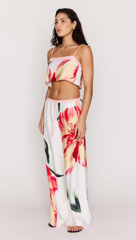 Model wearing a Macro Floral Print Cropped Cami with wide-legged pants featuring vibrant floral patterns.