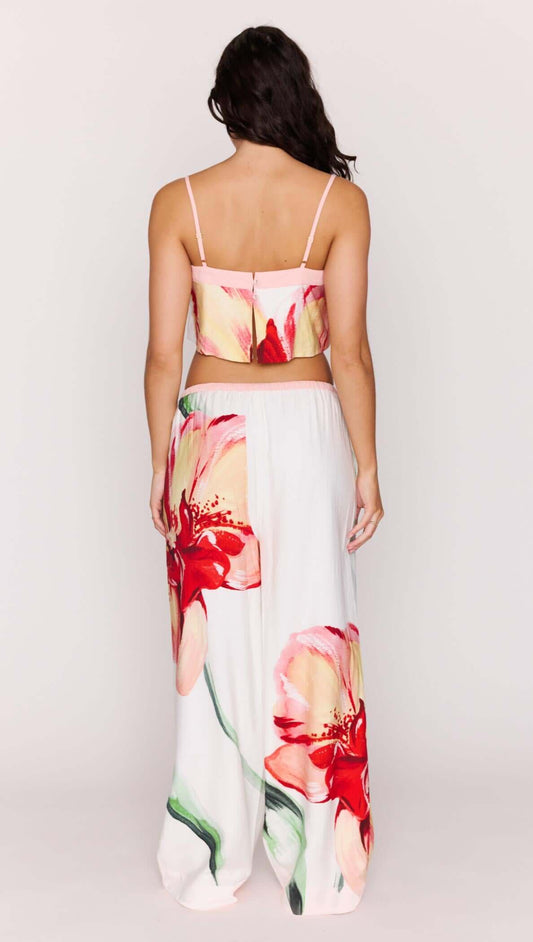 Back view of a model wearing a Macro Floral Print Cropped Cami paired with floral pants.