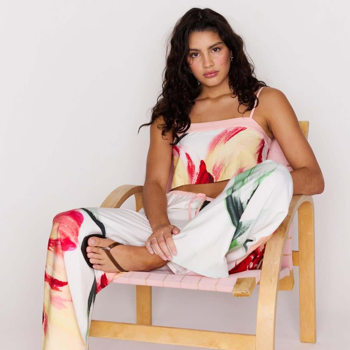 Macro Floral Print Drawstring Pants styled with a floral top, model sitting on a chair with a relaxed look.