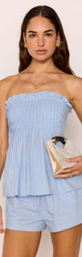 Model wearing Cotton Linen Blend Blue Relaxed Shorts and a blue strapless top, holding a clutch bag.