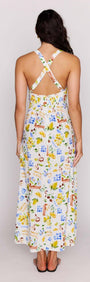 Back view of a woman wearing the Mediterranean Print Halter Midi Dress with a cross-back detail and vibrant floral print.