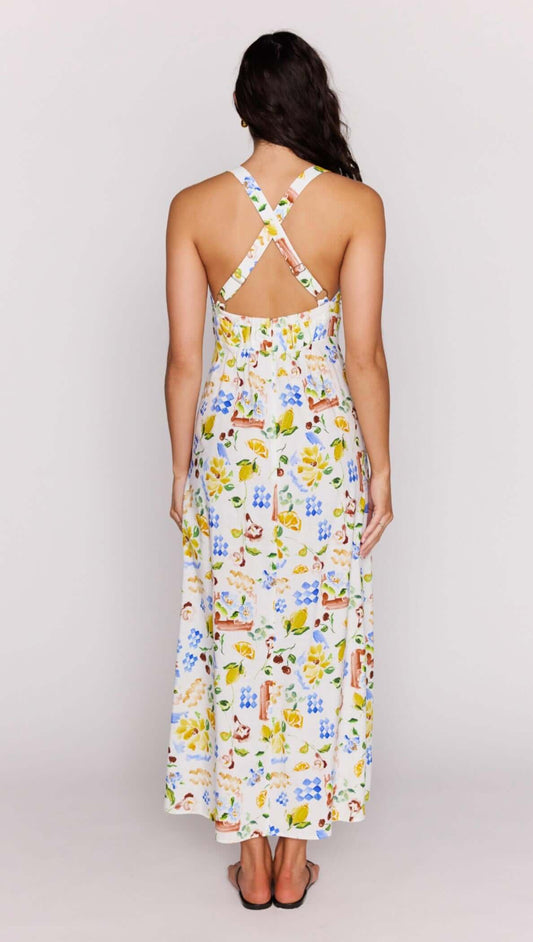Back view of a woman wearing the Mediterranean Print Halter Midi Dress with a cross-back detail and vibrant floral print.