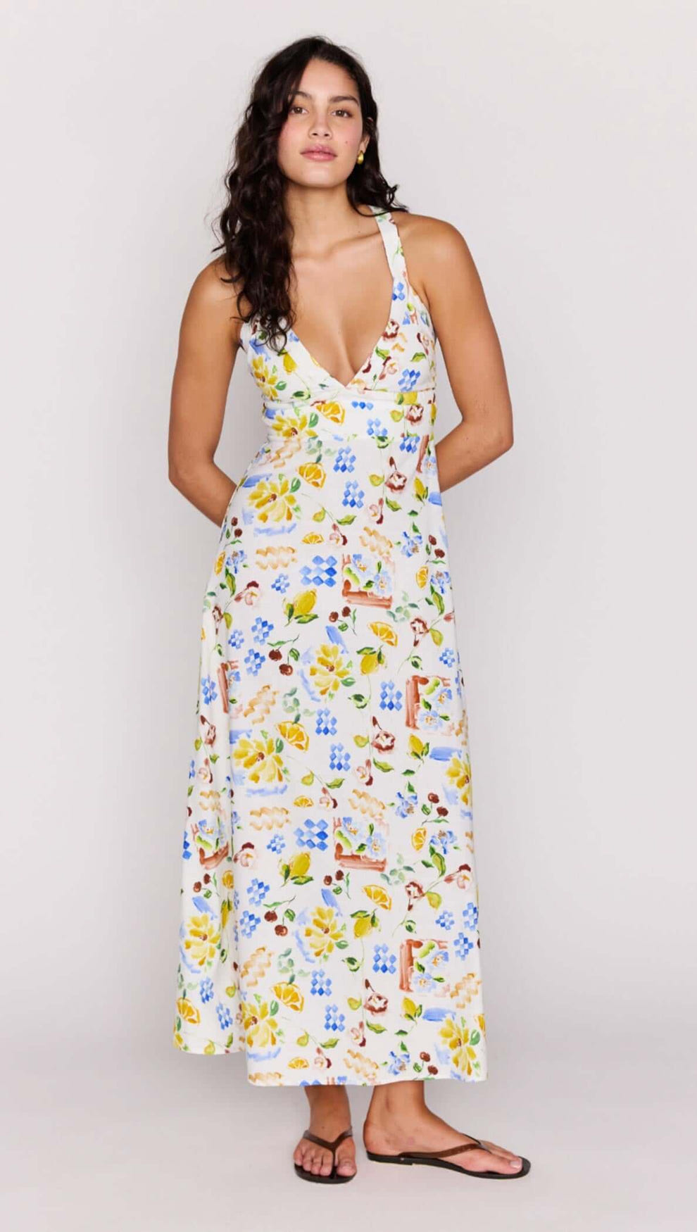 A model wearing the Mediterranean Print Halter Midi Dress featuring a V-neckline and cross-back detail.