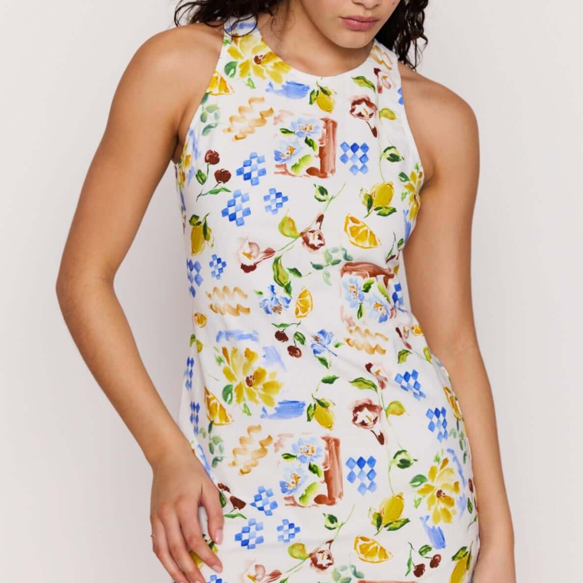 Model wearing a Mediterranean Print Open Back Mini Dress with vibrant citrus and floral patterns.