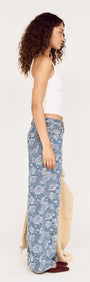 Model wearing Mid Rise Floral Denim Wide Leg Jeans, showcasing side view with soft floral design and relaxed fit.