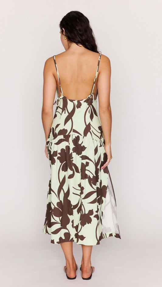 Back view of a model wearing the Mint Chocolate Cotton Floral Deep V Midi Dress with a flowing skirt and slender straps.