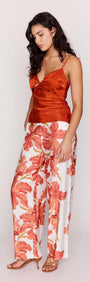 A model showcases the Orange Bead Detail Satin Cami paired with vibrant floral pants for a stylish look.