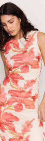 Model wearing the Peach Hibiscus Mesh Midi Dress featuring a bold peach floral print and subtle ruching.