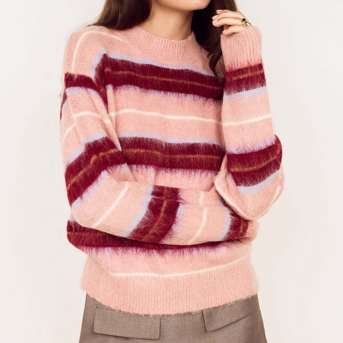 Model wearing a Pink Brushed Stripe Crew Neck Sweater styled with a mini skirt, showcasing cozy and vibrant hues.