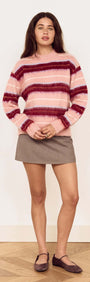 A model wearing the Pink Brushed Stripe Crew Neck Sweater over a mini skirt, highlighting its soft, trendy design.
