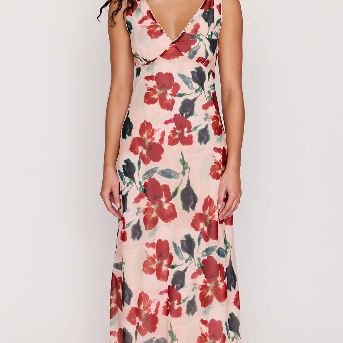 Model wearing a Pink Floral Bias Midi Dress featuring a deep V-neckline and vibrant floral print.