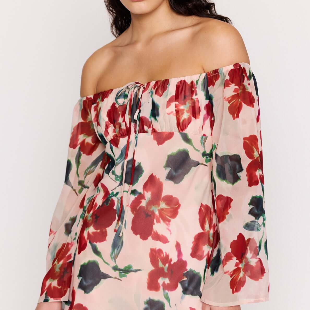 Pink Floral Off Shoulder Dress worn by a model, featuring a soft floral print and off-the-shoulder neckline.