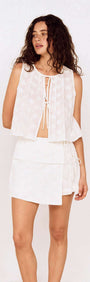 Model wearing a Pleated Broderie Anglaise Tie Front Cotton Top styled with a matching skirt, showcasing a feminine summer look.