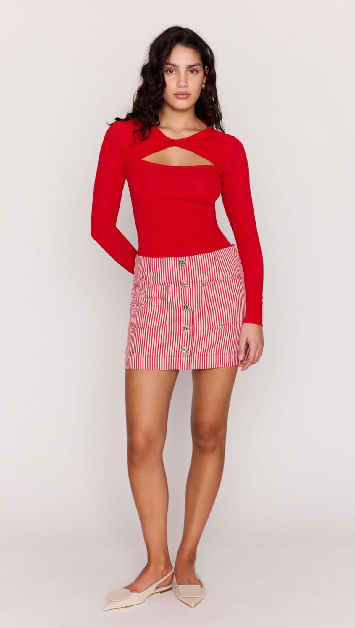 Model wearing a Red Pinstriped Denim Mini Skirt paired with a red long-sleeve top, showcasing a stylish summer outfit.