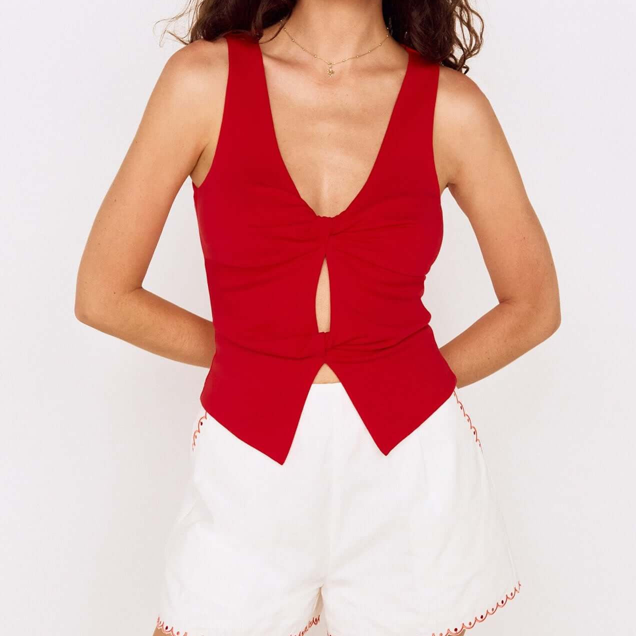 Model wearing a Red Twist Front Jersey Top paired with white shorts, showcasing a stylish summer outfit.