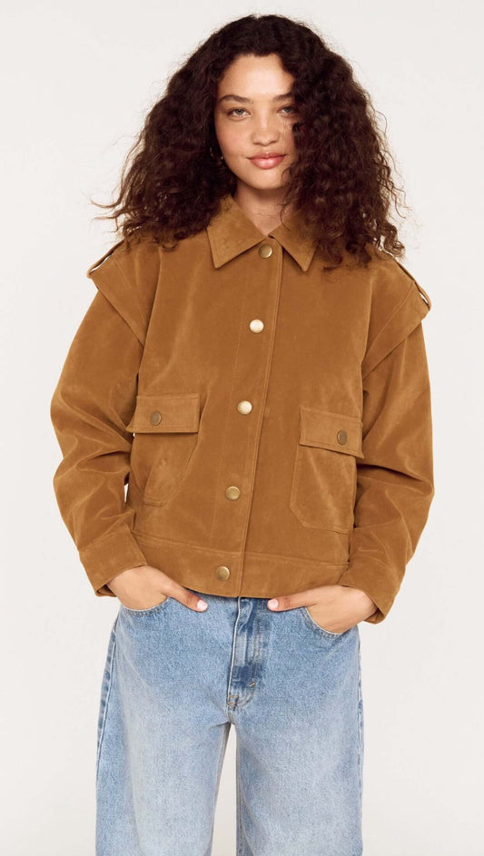 Model wearing a Relaxed Fit Faux Suede Jacket in brown with large pockets and a collared neckline, paired with blue jeans.
