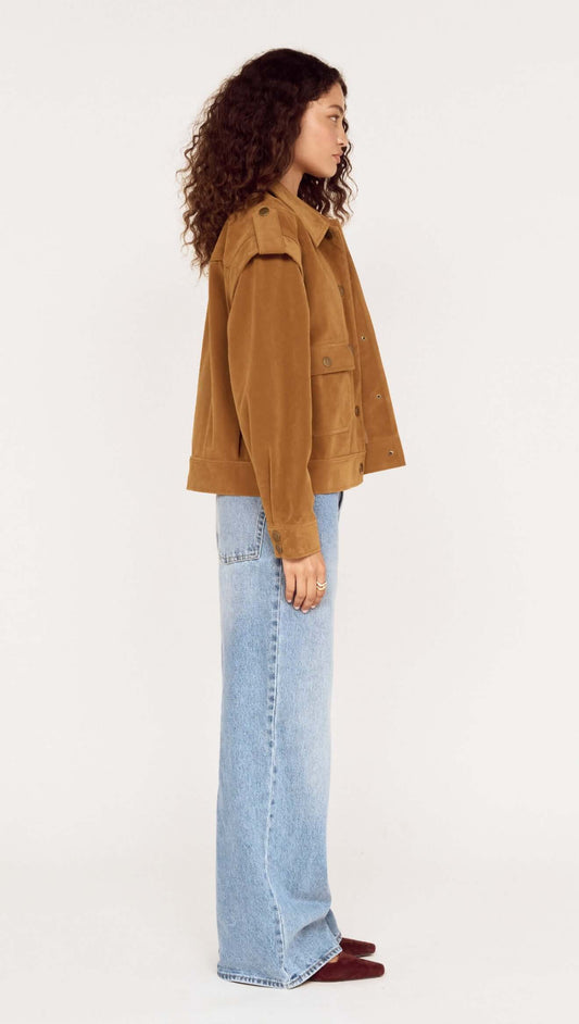 Side view of a model wearing a Relaxed Fit Faux Suede Jacket with light blue jeans against a neutral background.