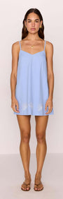 Cotton Blend Blue Embroidered Mini Dress worn by a model, featuring adjustable spaghetti straps and shell embroidery.