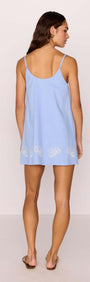 Back view of model wearing Cotton Blend Blue Embroidered Mini Dress with shell embroidery and adjustable spaghetti straps.