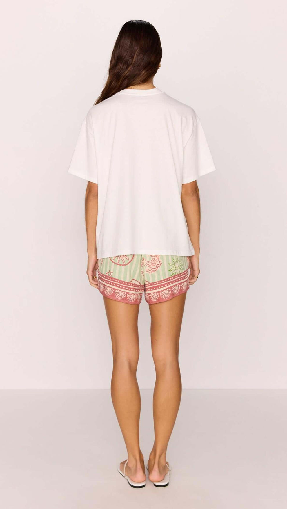 Back view of a model wearing a Cotton Mermaid Print T-Shirt with patterned shorts.