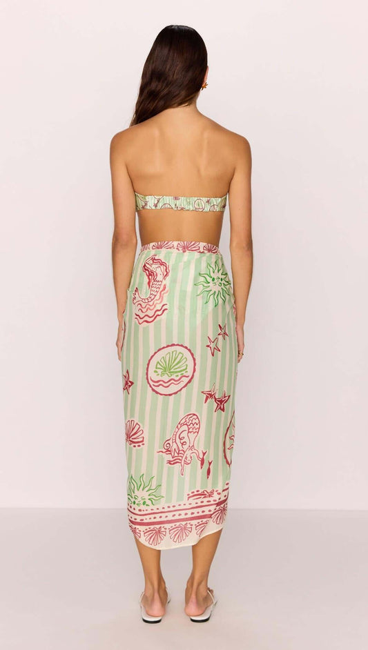 Back view of a woman wearing a Green Stripe Printed Sarong styled as a beach wrap.