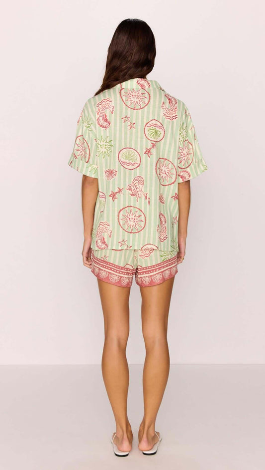 Back view of a model wearing a Linen Blend Green Stripe Printed Shirt with matching shorts.