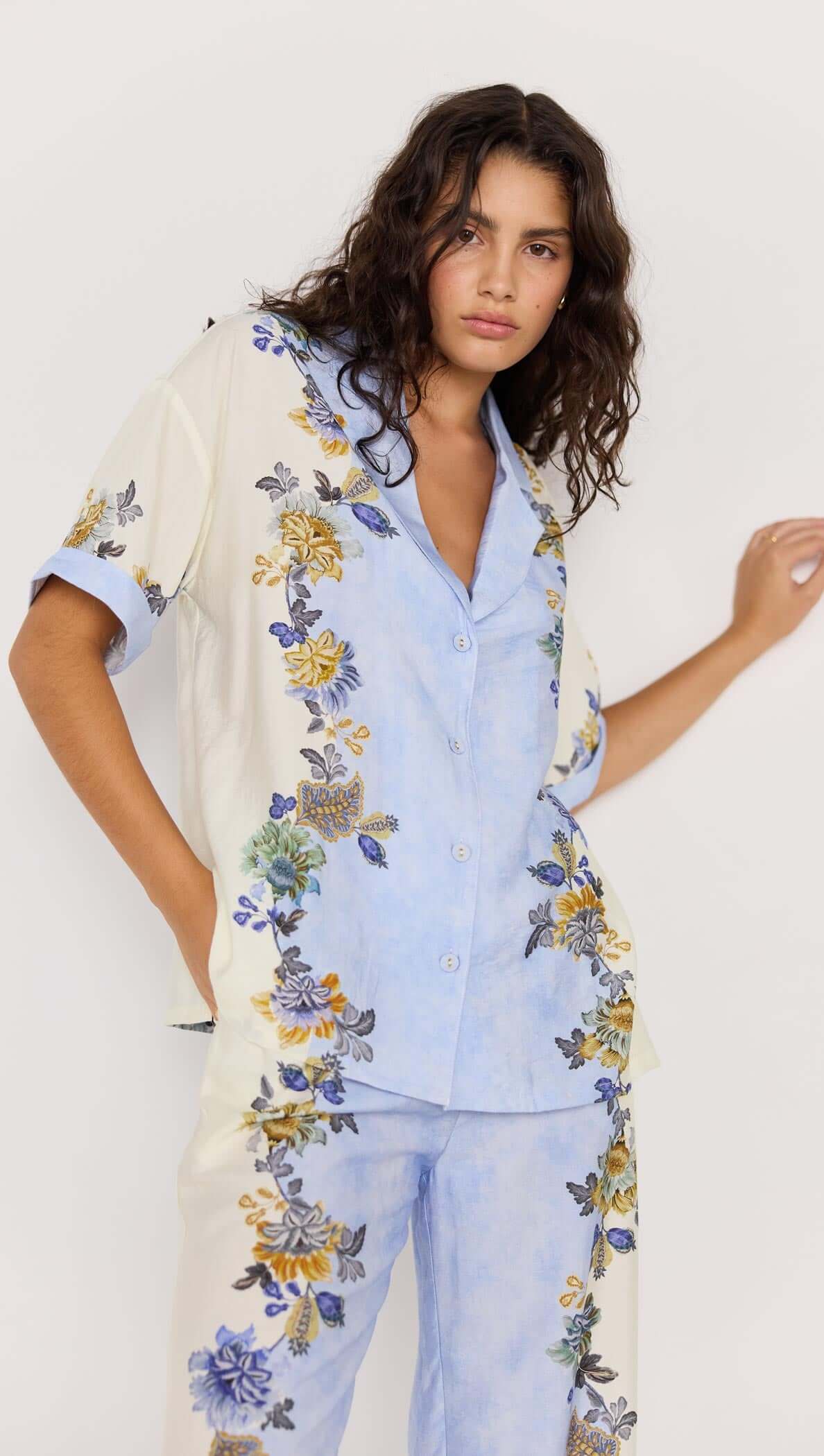 Model wearing Lucia blue floral resort shirt with matching pants, showcasing a relaxed silhouette and vibrant floral print.