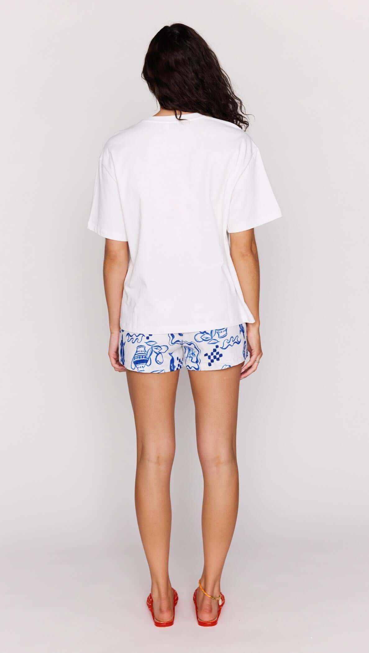 Back view of a woman wearing a Statement Relaxed Oversized Cotton Tee with colorful shorts.