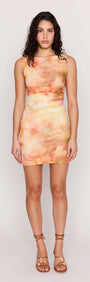 Model wearing a Sunset Tonal Mesh Mini Dress with a watercolor-inspired print in warm sunset colors.