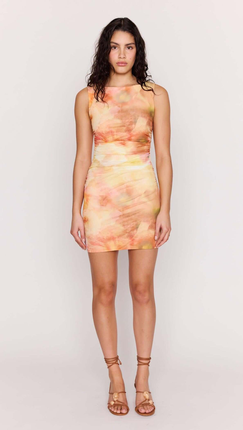 Model wearing a Sunset Tonal Mesh Mini Dress with a watercolor-inspired print in warm sunset colors.