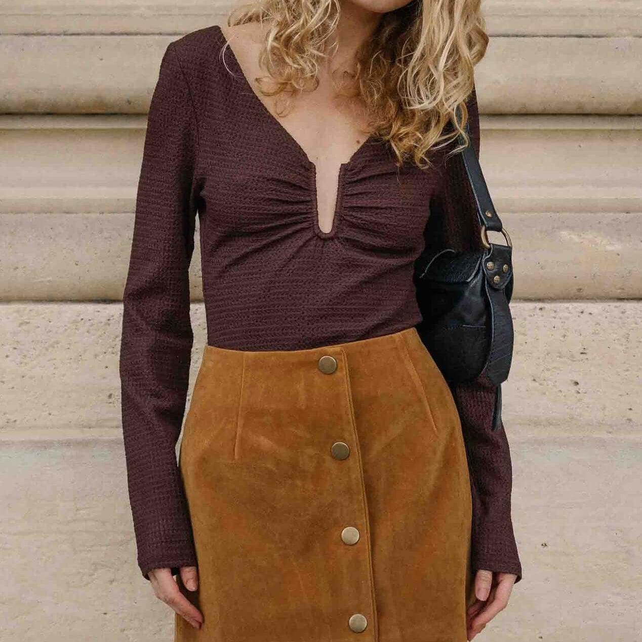 Model wearing U Wire Textured Jersey Top in Chocolate with a suede skirt, showcasing a stylish and trendy outfit.