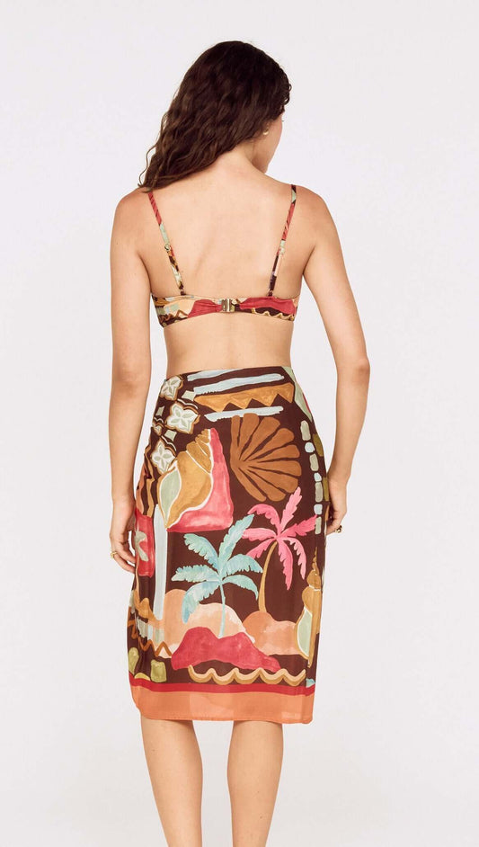Back view of a model wearing a Vintage Coastal Print Gathered Bikini Top paired with a colorful wrap skirt.